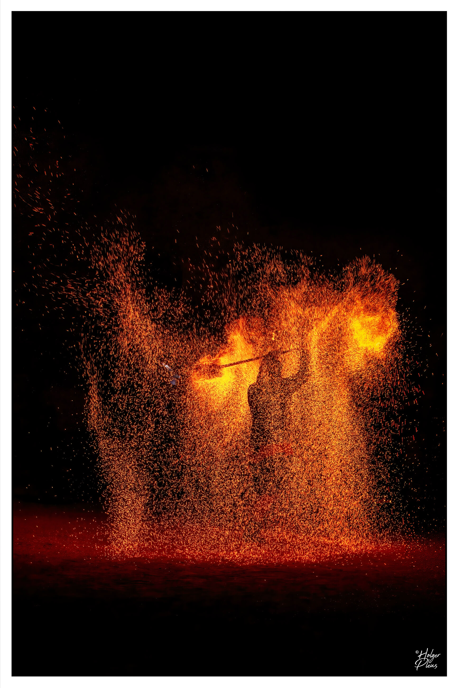 Fotografie eines Jongleurs, der mit Feuer jongliert